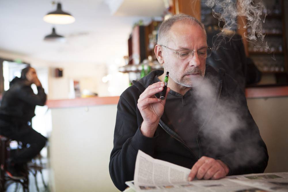 Man with an electronic cigarette in a public place.