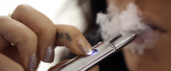 An employee poses for a photograph smoking a V-Revolution e-cigarette inside the company's store in London, U.K., on Wednesday, Oct. 16, 2013. The U.S. Food and Drug Administration is set to decide this month whether to lump e-cigarettes in with conventional smokes as part of its oversight of the $90 billion U.S. tobacco market. Photographer: Chris Ratcliffe/Bloomberg via Getty Images